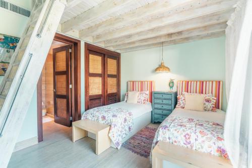 2 camas en un dormitorio con techos de madera en Nearby beach and beach club at Portillo NF, en Las Terrenas