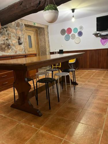a large wooden table in a room with chairs at Benedita's House in Capinha