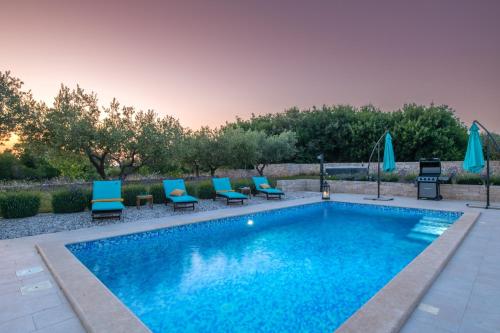 uma piscina com espreguiçadeiras azuis e uma piscina em Villa Silentio em Marčana