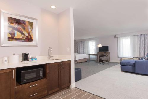 Habitación de hotel con cocina y sala de estar. en Hampton Inn and Suites Michigan City en Michigan City