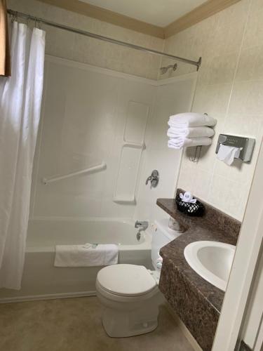 a white bathroom with a toilet and a sink at Cairns Motel in Summerside