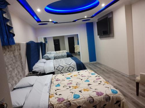 a bedroom with two beds and a blue ceiling at Hostal Boston 2 in Quito