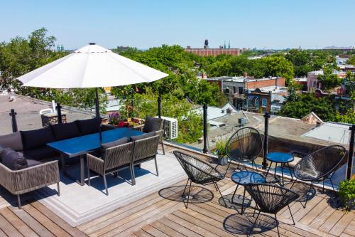 a patio with a table and chairs and an umbrella at Parc Avenue Hostel in Montréal