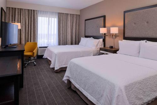 a hotel room with two beds and a flat screen tv at Hampton Inn Pittsburgh - Wexford - Cranberry South in Wexford