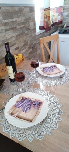 a table with two glasses of wine and a plate of food at Kristi Lux Jezero - NEW Studio apartment with Balcony and FREE Parking in Veliko Gradište