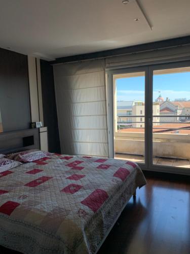une chambre avec un lit et une grande fenêtre dans l'établissement Duplex Alsace Lorraine, jolie appartement, à Nice