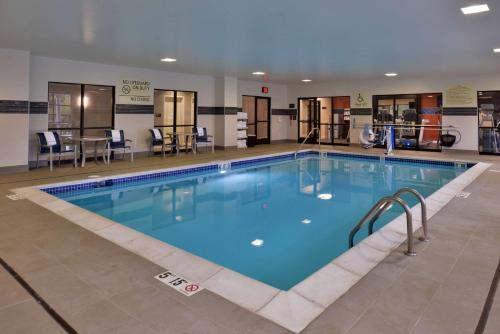 a large swimming pool with blue water in a building at Hampton Inn & Suites Ann Arbor West in Ann Arbor