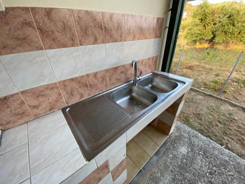 a stainless steel sink in a room with a window at O κήπος της Εδέμ / Garden of Eden in Sagiada