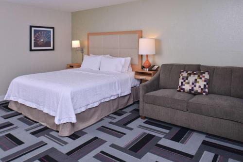 um quarto de hotel com uma cama e um sofá em Hampton Inn and Suites Ames, IA em Ames