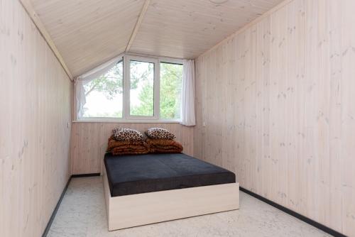 a bed in a room with a window at Paukšcių takas Vertikalė poilsio namai in Šventoji