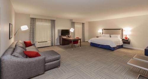 a hotel room with a bed and a couch at Hampton Inn Emerson - Lakepoint, Ga in Cartersville