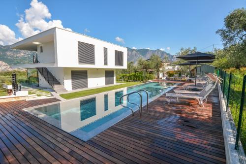 uma casa com uma piscina num deque de madeira em Olivo Luxury Apartments em Malcesine