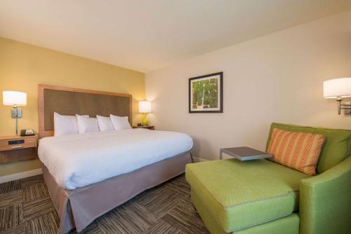 a hotel room with a bed and a chair at Hampton Inn Waynesboro in Waynesboro