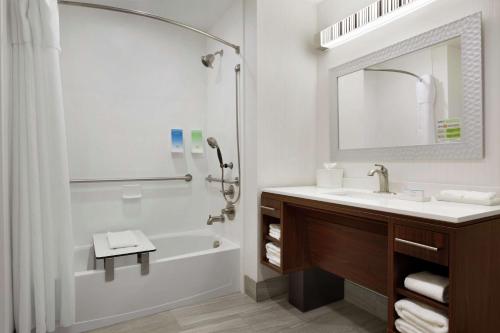 西門羅的住宿－Home2 Suites by Hilton West Monroe，带浴缸、水槽和镜子的浴室