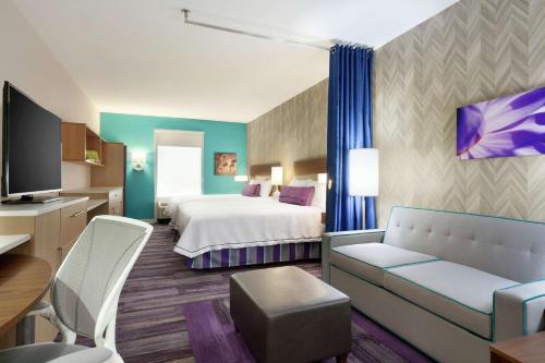 ウェスト・モンローにあるHome2 Suites by Hilton West Monroeのベッドとソファ付きのホテルルーム