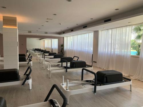 a row of exercise equipment in a room with windows at Mediterraneo Sitges in Sitges
