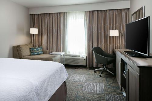 a hotel room with a bed and a flat screen tv at Hampton Inn & Suites Mason City, IA in Mason City