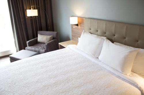 a bedroom with a large white bed and a chair at Hampton Inn by Hilton Durango in Durango