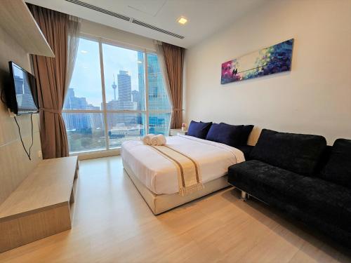 a hotel room with a bed and a couch at Bukit Bintang KLCC Binjai 8 Premium Soho Apartment by Sarah's Lodge in Kuala Lumpur