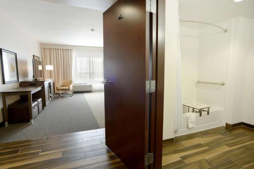 a hotel room with a door leading into a room with a desk at Hampton Inn & Suites Ponca City in Ponca City