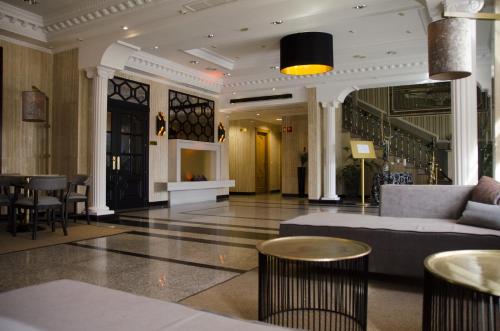 a lobby of a hotel with a couch and tables at Hotel Complejo París in Illescas