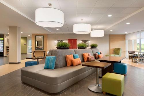 a living room with a couch with colorful pillows at Home2 Suites by Hilton Milwaukee Brookfield in Waukesha