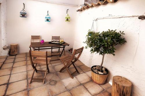 uma sala de jantar com uma mesa e cadeiras e um vaso de plantas em Casa el Tratado, situada en el casco histórico con patio privado em Tordesilhas
