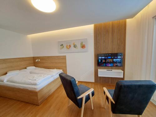 6bits Apartments في جيسينيك: غرفة نوم بسرير وكرسيين