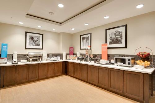 a restaurant with a counter with aasteryasteryasteryasteryasteryasteryasteryasteryastery at Hampton Inn & Suites Los Angeles - Glendale in Glendale