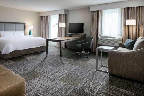 Hampton Inn & Suites-Hudson Wisconsin في هدسون: غرفة في الفندق مع سرير ومكتب