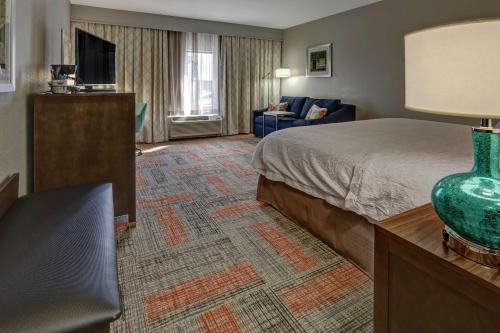 um quarto de hotel com uma cama e um sofá em Hampton Inn Summerville SC em Summerville