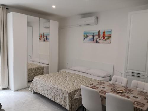 Un dormitorio con una cama y una mesa y sillas. en Casa Vacanze Maia, en Gaeta