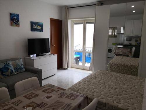 ein kleines Wohnzimmer mit einem Bett und einem TV in der Unterkunft Casa Vacanze Maia in Gaeta
