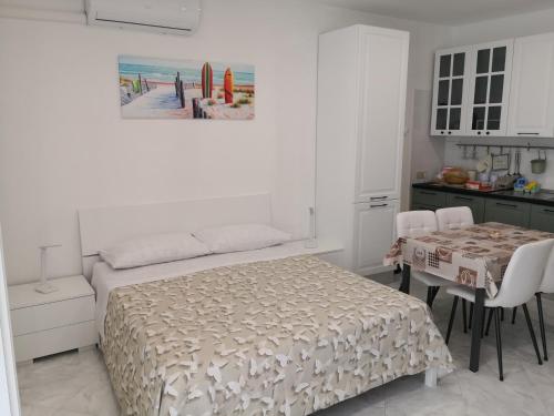 ein Schlafzimmer mit einem Bett und einem Tisch sowie eine Küche in der Unterkunft Casa Vacanze Maia in Gaeta