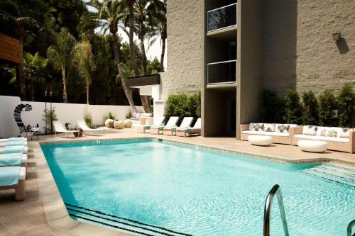 聖地牙哥的住宿－拉霍亞希爾頓Curio Collection酒店，一座带椅子的大型游泳池和一座建筑