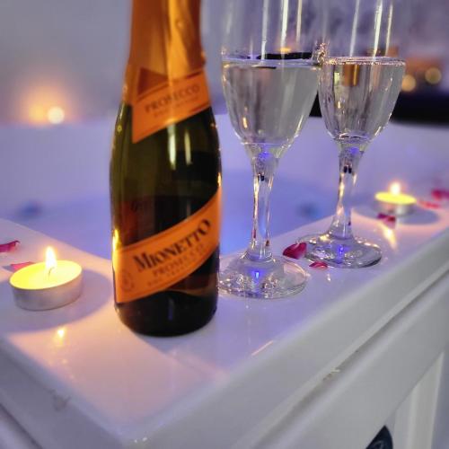 a bottle of champagne and two glasses on a table at Escapada romantica cu jacuzzi in Chisinau in Chişinău