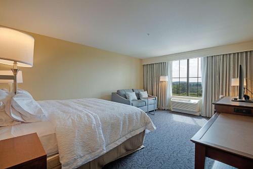 Hampton Inn & Suites Cazenovia, NY في Cazenovia: غرفه فندقيه بسرير وكرسي