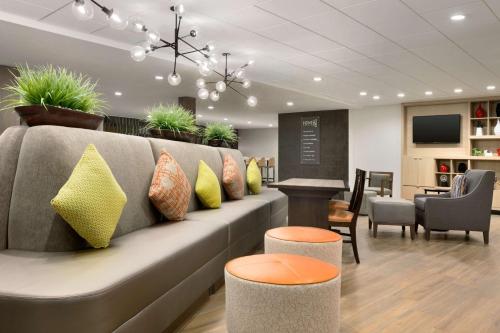 a waiting room with a couch with pillows on it at Home2 Suites by Hilton Shenandoah The Woodlands in The Woodlands
