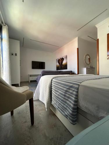 a bedroom with two beds and a chair at Casa Daniella Vivienda B in Ingenio