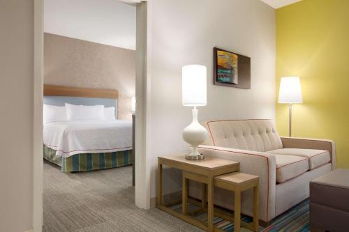 a hotel room with a bed and a couch and a chair at Home2 Suites by Hilton Shenandoah The Woodlands in The Woodlands