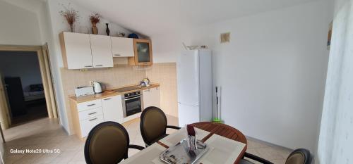 uma cozinha com uma mesa e cadeiras e um frigorífico em Gabi em Ðuraševići