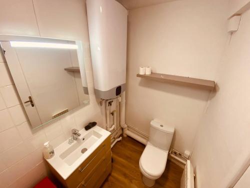 une salle de bain avec des toilettes blanches et un lavabo dans l'établissement Le refuge des voyageurs-255, à Rouen