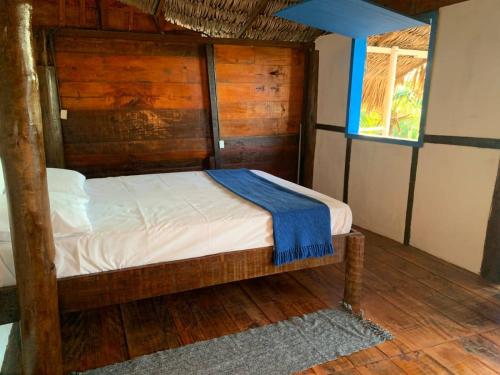 a bedroom with a wooden bed in a room at DuMangue Kite House in Guriú