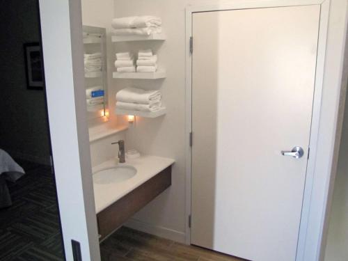 a bathroom with a sink and a mirror and towels at Hampton Inn McPherson in McPherson