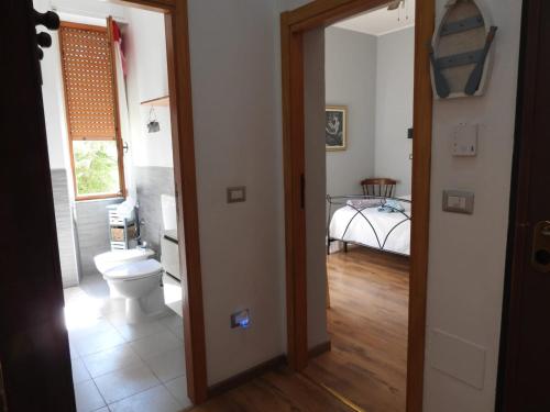 uma casa de banho com WC e um quarto com cama em Nonna Giusy em Alghero