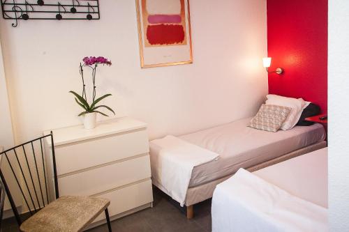 - une chambre avec un lit et une commode avec une plante dans l'établissement Villa Schiller, 2 studios côté jardin - quartier Orangerie, à Strasbourg