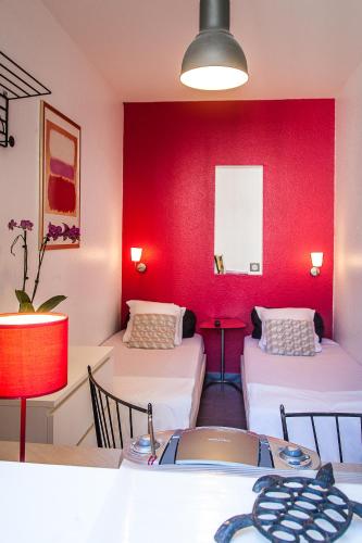 Cette chambre comprend deux lits et une table avec des chaises. dans l'établissement Villa Schiller, 2 studios côté jardin - quartier Orangerie, à Strasbourg