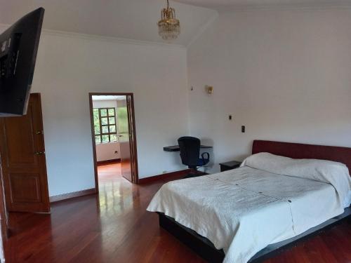 ein Schlafzimmer mit einem Bett und einem TV in der Unterkunft Gran habitación/jacuzzi/nor-occidente in Bogotá