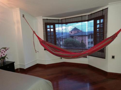 eine Hängematte in einem Zimmer mit einem großen Fenster in der Unterkunft Gran habitación/jacuzzi/nor-occidente in Bogotá