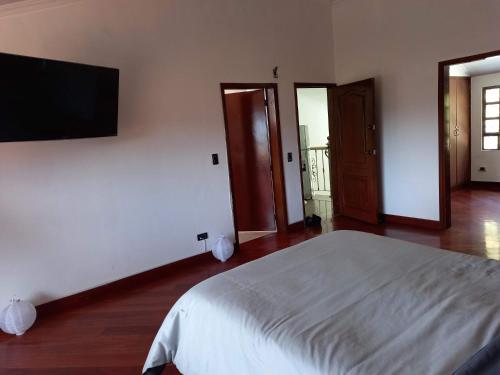 Schlafzimmer mit einem Bett und einem Flachbild-TV in der Unterkunft Gran habitación/jacuzzi/nor-occidente in Bogotá